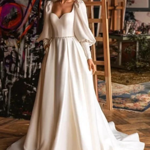 Robe de mariée trapèze en satin, manches longues bouffantes et décolleté en cœur
